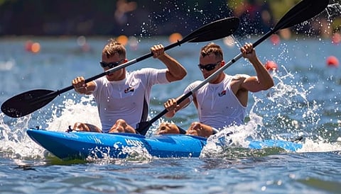 कैनो स्प्रिंट प्रतियोगिता में खिलाड़ी पानी में रेस लगाते हुए|