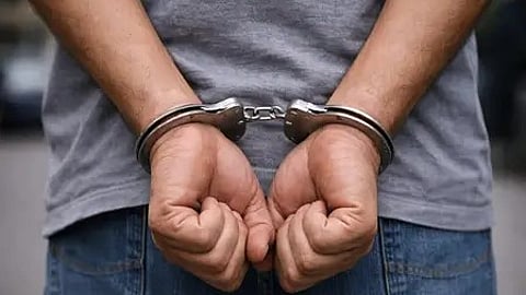 हाथ में हाथकड़ी पहने एक आरोपी|