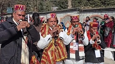 इस तस्वीर में कुछ आदमी वाद्य यन्त्र बजा रहे हैं।