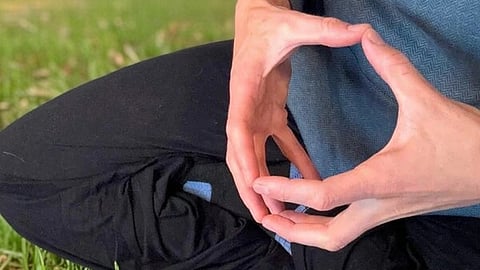 इस इमेज में एक व्यक्ति को योग मुद्रा में देखा जा सकता है।