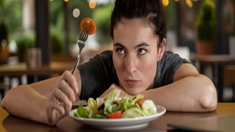 इस इमेज में एक औरत को खाना खाते हुए देखा जा सकता है।