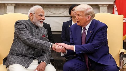 एक औपचारिक बैठक के दौरान नरेंद्र मोदी और डोनाल्ड ट्रंप हाथ मिलाते नजर आ रहे हैं। दोनों मुस्कुरा रहे हैं, पीछे अन्य अधिकारी भी दिखाई दे रहे हैं।