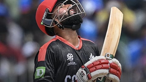 कनाडा का एक खिलाड़ी जो आसमान की तरफ देख रहा है और हाथ में बल्ला पकड़े हुए है