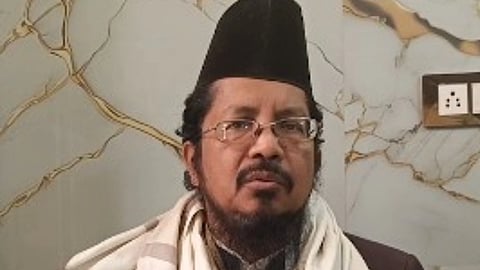 मौलाना शहाबुद्दीन रजवी जिनके सिर पर काले रंग की टोपी है और कुछ बोलने का प्रयास करते दिख रहे हैं