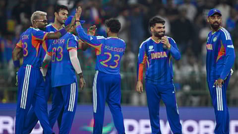 भारतीय क्रिकेट टीम के खिलाड़ी जश्न मनाते हुए, नीली जर्सी में नज़र आ रहे हैं।