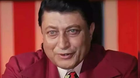 लाल रंग के सूट में भारतीय अभिनेता जो गंभीर मुद्रा में दिख रहा है।