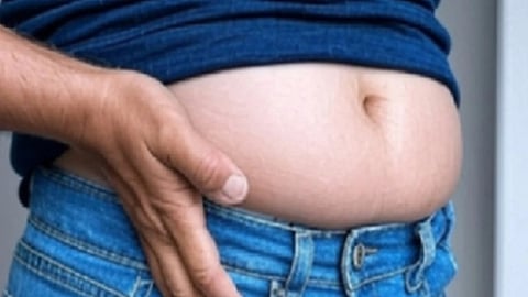 उभरे हुए पेट पर हाथ रखते हुए व्यक्ति, वजन बढ़ने और थायरॉयड से जुड़ी समस्या को दर्शाता दृश्य