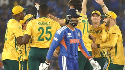 भारत का बल्लेबाज आउट होकर जाता हुआ और पीछे दक्षिण अफ्रीका के खिलाड़ी जश्न मनाते हुए।