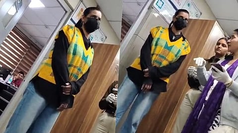 इस दृश्य एक लड़की अपना चेहरा मास्क से ढकी हुई नजर आ रही है