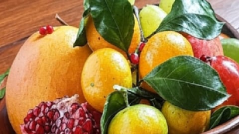 एक कटोरे में टेबल पर कई प्रकार के फल रखे हुए