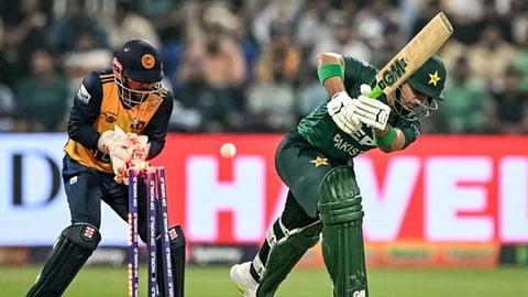 क्रिकेट मैच के दौरान पाकिस्तान का बल्लेबाज़ शॉट खेलते हुए, पीछे विकेटकीपर स्टंप के पास खड़ा है और गेंद स्टंप्स से टकराती दिख रही है।
