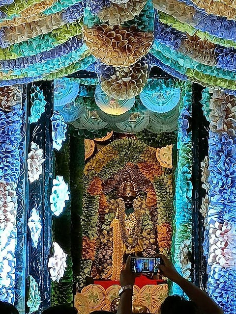 भगवान की प्रतिमा में चार चांद लगाते हुए यह नोटों की सजावट। (IANS)