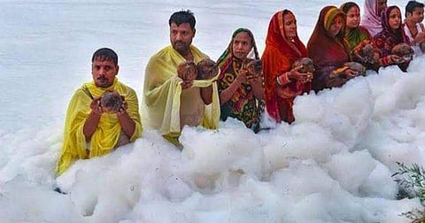 इस फोटो को देख कर लग रहा होगा कि यह सभी लोग बादलों में हैं, पर यह लोग दिल्ली की प्रदूषित यमुना नदी में मजबूरन आस्था की डुबकी लगा रहे हैं (Twitter)