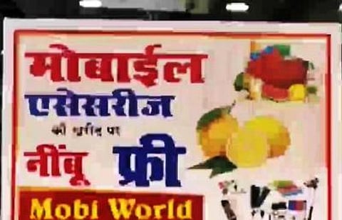 वाराणसी में एक दुकानदार मोबाइल एक्सेसरीज की खरीदारी पर फ्री नींबू दे रहा है। (IANS)