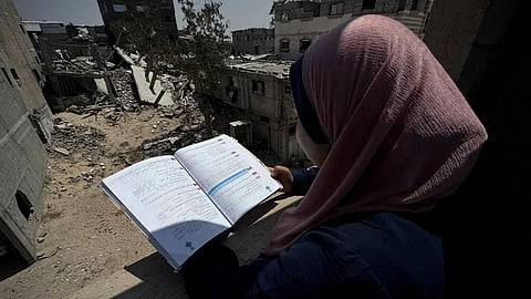 A Palestinian student studies inside a tent