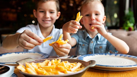 medium-shot-smiley-boys-eating-fries