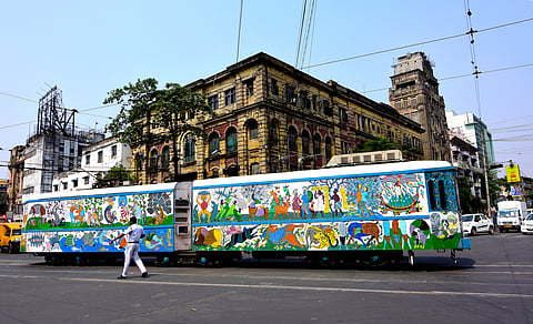 A tram on a city road with colonial-era office buildings in the background of the Esplanade area of Kolkata