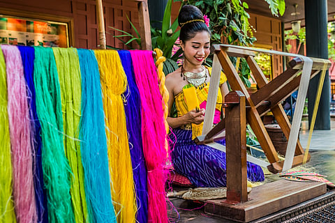 A weaver spinning silk at the Jim Thompson House Museum in Bangkok