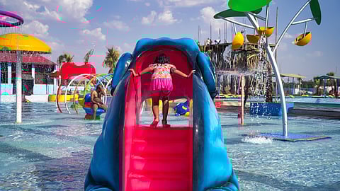 A girl climbs a water slide in a water park