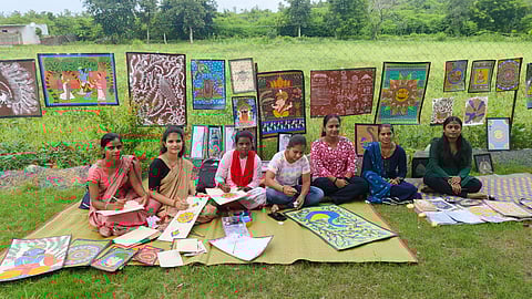 Girls painting traditional Bundeli art on papaya leaves at a homestay in Ladpura Khas, Madhya Pradesh