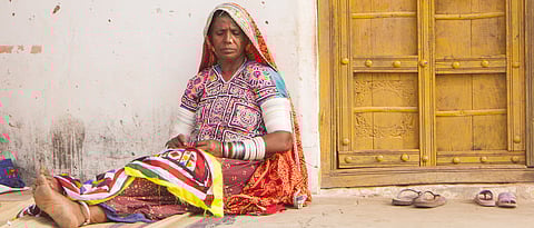 A traditional woman working on an ethnic embroidered cloth