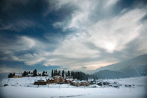 A thick coat of snow covers the houses and meadows of Gulmarg