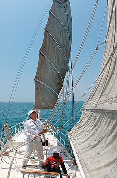 Dr John, expat Brit, trims the Rosa's sails, the first recreational yacht on the Registrar of Indian Shipping