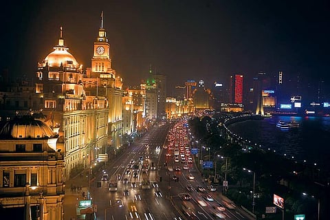 The Bund lit up for the evening, the green copper spire of the Peace Hotel in the mid distance