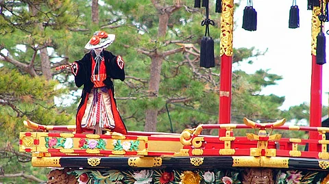 A marionette performs atop a Matsuri float