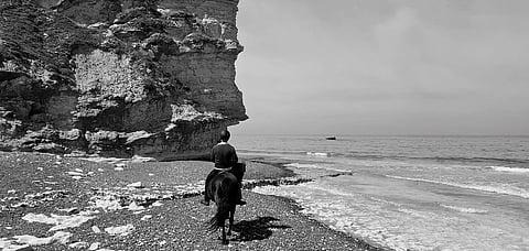 To pass below the overhang of the cliff, we had to dismount and lead our frightened horses across during the few seconds reprieve between two waves