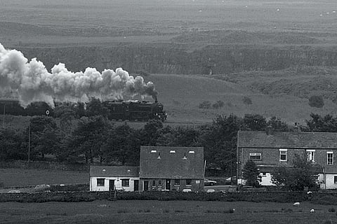 A steam train chugging through the countryside on its way to the Ribblehead viaduct