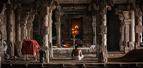 A priest sits alone and offers prayers