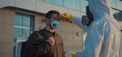 Representative image A medical worker screens passengers