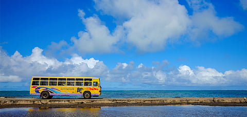 A bus driving between the sea and the lake on the coastal highway of Port Sud-Est in Mauritius