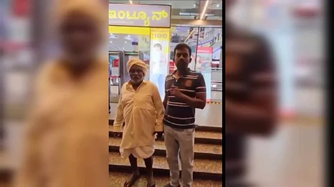 শপিং মলের সামনে প্রৌঢ় এবং তাঁর ছেলে