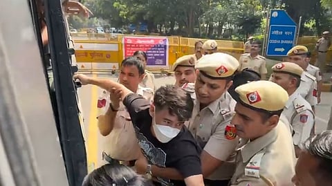 এক আন্দোলনকারীকে নিয়ে যাচ্ছে পুলিশ