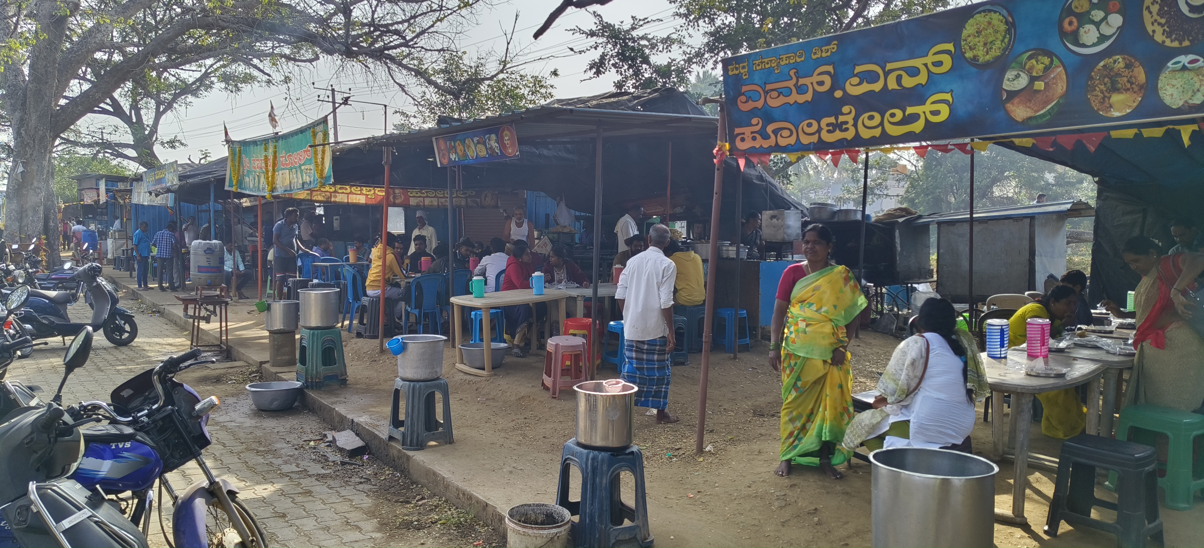 ಕೊಳ್ಳೇಗಾಲದ ತಾಲ್ಲೂಕು ಕಚೇರಿ ಮುಂಭಾಗದಲ್ಲಿರುವ ಆಹಾರ ಮಳಿಗೆಗಳಲ್ಲಿ ಗ್ರಾಹಕರು ಆಹಾರವನ್ನು ಸೇವಿಸುತ್ತಿರುವುದು