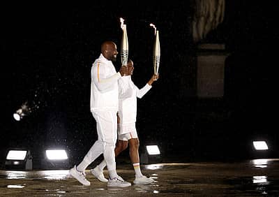 ಒಲಂಪಿಕ್ ಜ್ಯೋತಿ ಹಿಡಿದು ನಡೆದ ಎಡ್ಡಿ ರೈನರ್ ಮತ್ತು ಮೇರಿ ಜೋಸ್ ಪೆರೆಕ್