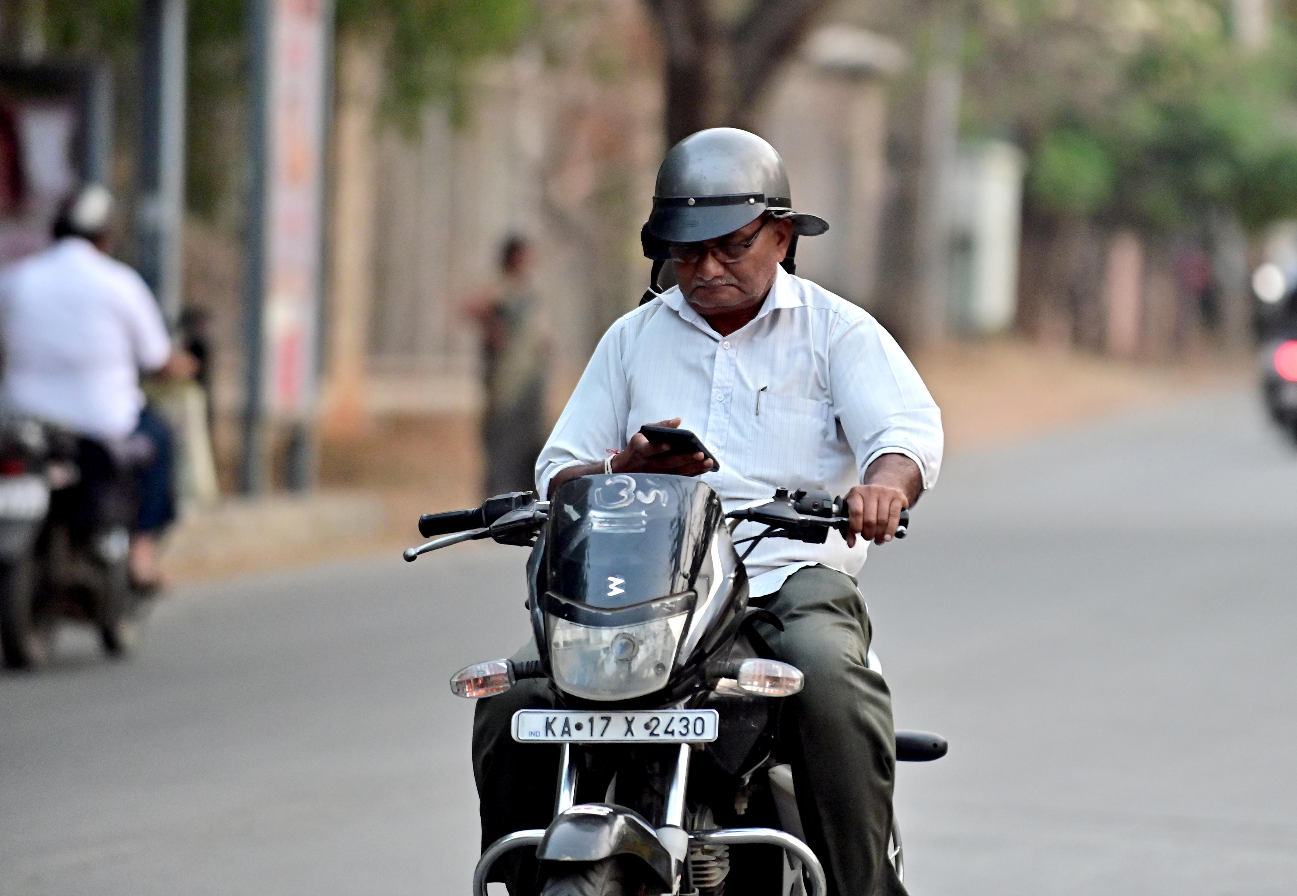 ದಾವಣಗೆರೆಯ ಕುವೆಂಪು ಕನ್ನಡ ಭವನ ರಸ್ತೆಯಲ್ಲಿ ಬೈಕ್ ಓಡುಸುತ್ತಲೇ ಮೊಬೈಲ್ ಬಳಸುತ್ತಿರುವ ಸವಾರ –ಪ್ರಜಾವಾಣಿ ಚಿತ್ರ / ಸತೀಶ ಬಡಿಗೇರ್
