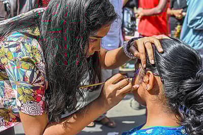 ಮುಖದ ಮೇಲೆ ಬಣ್ಣದಲ್ಲಿ ಚಿತ್ರ ಬಿಡಿಸುತ್ತಿರುವ ಯುವತಿ