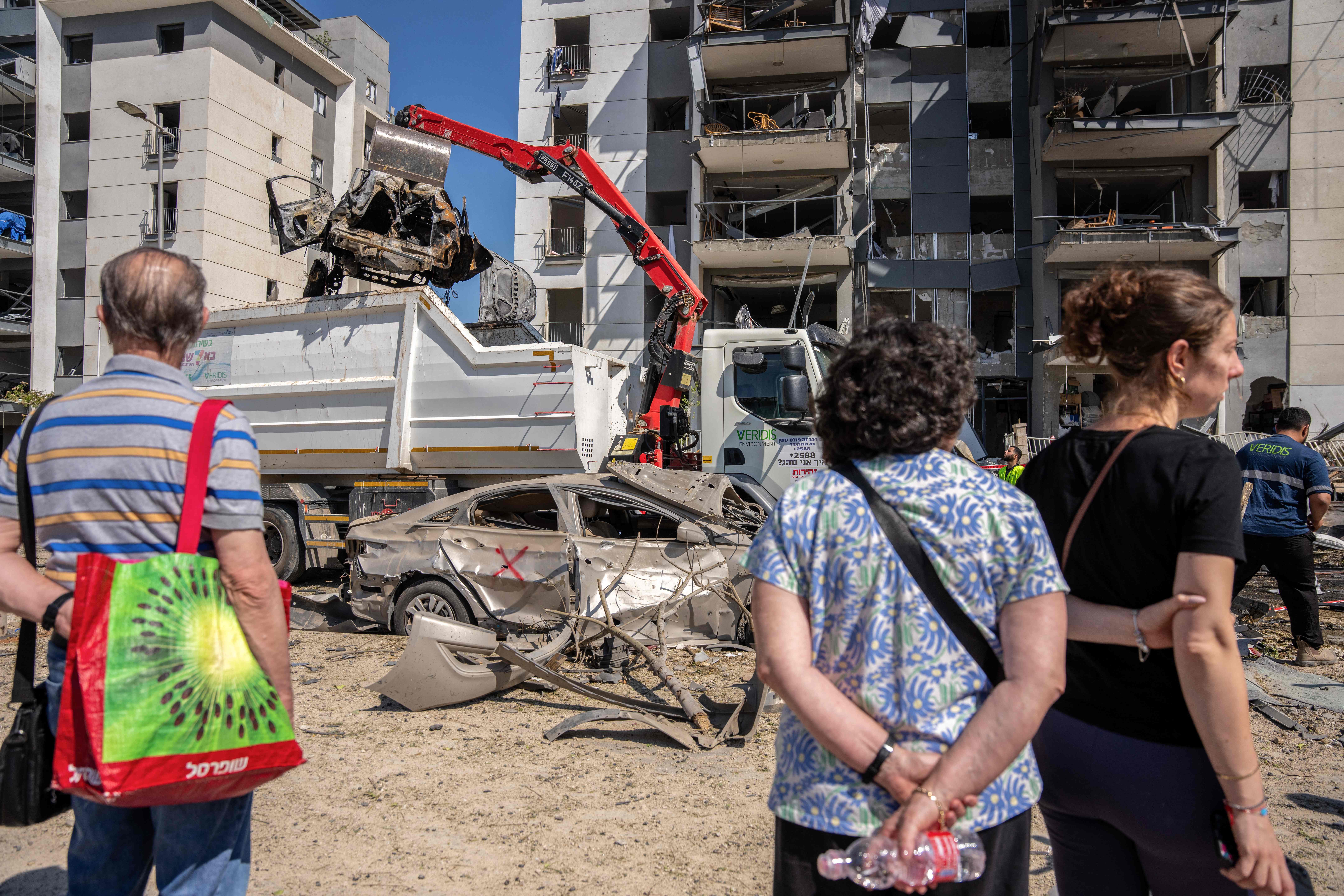 ಇರಾನ್ನ ಕ್ಷಿಪಣಿ ದಾಳಿಯಿಂದ ತೀವ್ರ ಹಾನಿಗೊಂಡಿರುವ ಇಸ್ರೇಲ್ನ ಬೀರ್ಶೆಬಾ ನಗರದ ವಸತಿ ಸಂಕೀರ್ಣದ ಬಳಿ ಅವಶೇಷ ತೆರವು ಕಾರ್ಯವನ್ನು ನಿವಾಸಿಗಳು ವೀಕ್ಷಿಸಿದರು –ಎಎಫ್ಪಿ ಚಿತ್ರ