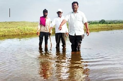 कारखेल येथील कोरेश्वर मंदिर परिसरात वीज पडल्या ठिकाणी पाणी दाखवताना शेतकरी.
