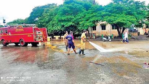 कोल्हापूर : सीपीआर चौक ते महावीर कॉलेज चौक रोडवरील चिखल पाण्याच्या फवार्यांनी धुऊन काढताना महापालिकेच्या अग्निशमन विभागाचे कर्मचारी. (छाया : नाज ट्रेनर)