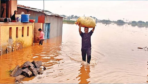 पूरग्रस्त आपला संसार डोक्यावर घेऊन बाहेर पडताना.