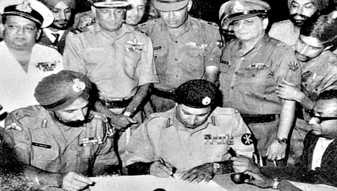 शरणागती पत्करल्यानंतर कागदपत्रांवर सही करताना पाकिस्तानचे तत्कालीन सेनानी लेफ्टनंट जनरल नियाजी.