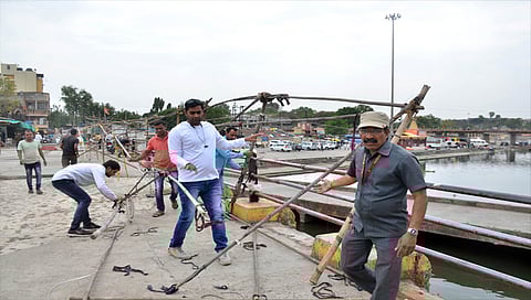 नाशिक : गोदाघाटावरील अतिक्रमण काढताना मनपा कर्मचारी. (छाया: हेमंत घोरपडे)