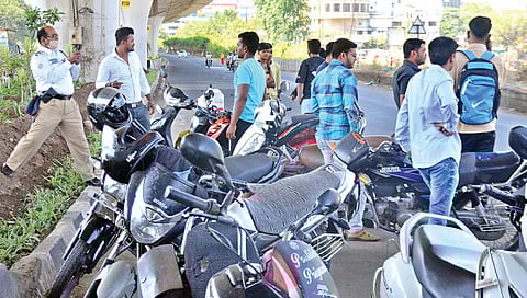 नाशिक ः विनाहेल्मेट चालकांना रोखताना वाहतूक पोलिस.