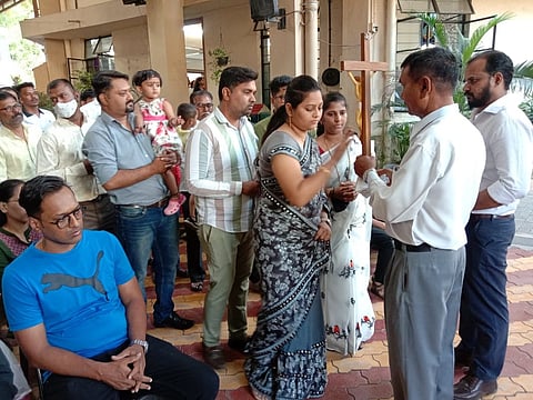 Christian brothers and sisters visiting the cross in a church in Pimpri.