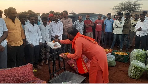 पिंपळनेर : किसान क्रांती भाजीपाला मार्केटच्या उद्घाटनप्रसंगी वजनकाट्याची पूजा करताना नागाई येथील महंत श्री १००८ प्रणव गिरीजा बाबाजी. समवेत शेतकरी व ग्रामस्थ. (छाया:अंबादास बेनुस्कर)