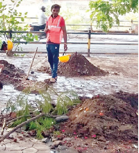 ओंकारेश्वर मंदिराच्या मागील बाजूस साफसफाईचे काम करताना कर्मचारी.